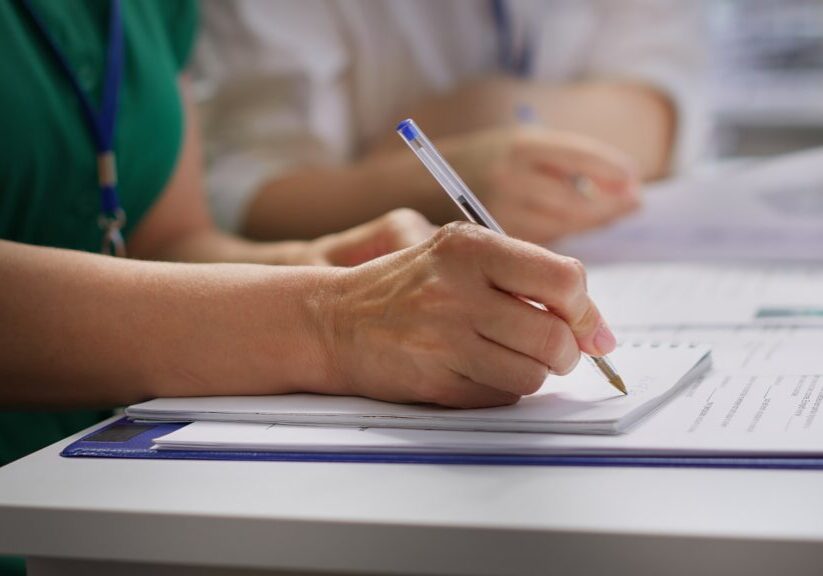 HR recruiters interviewing a job seeker and taking notes during meeting, attending an interview and conducting an evaluation. Headhunters and applicant in recruitment process. Close up. Camera A.